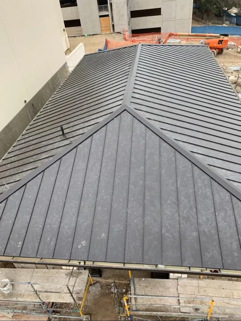 Commercial metal roof construction with crane equipment in Gresham
